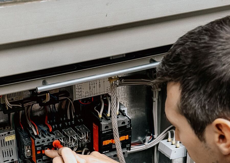 A skilled tradesperson using a multimeter to test an electrical panel